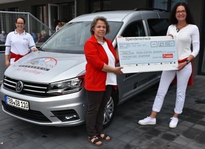Schecküberreichung vor dem neuen Caddy vor der Tagespflege.